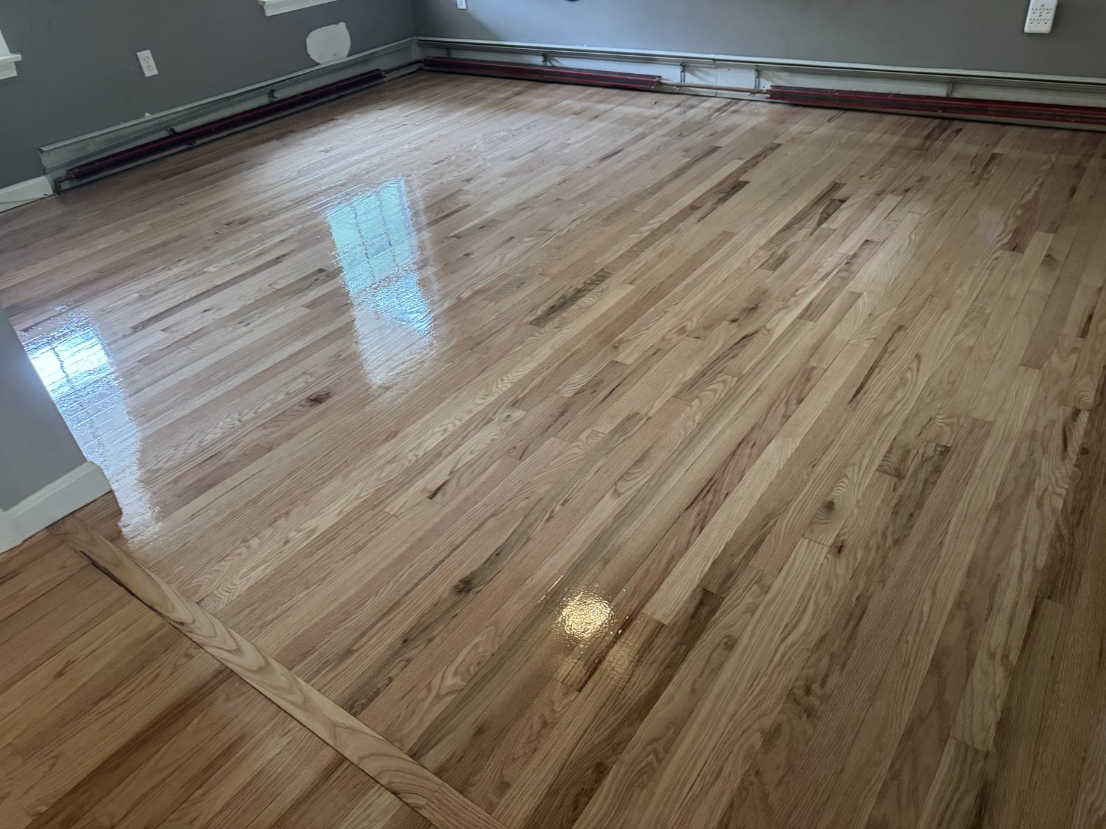 After hardwood floor restoration in Coventry, Rhode Island — finished room with natural light hardwood and a clean, glossy water-based polyurethane finish