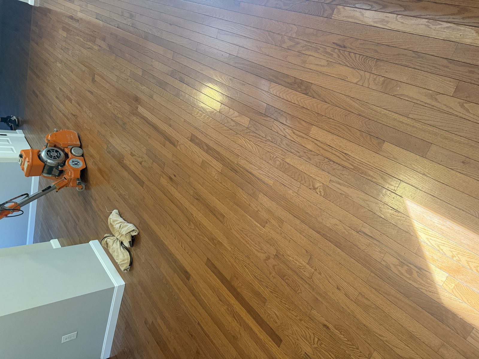 Before sanding in Coventry, Rhode Island — worn, dull prefinished hardwood floor with scratches and an old ambered stained finish