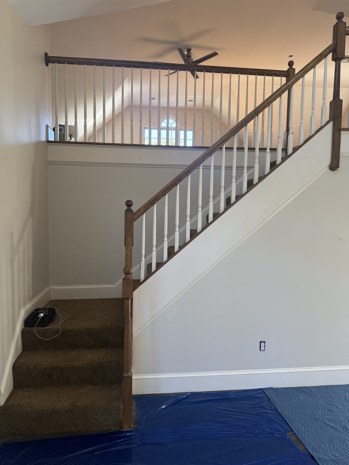 Lower flight of the original carpeted staircase with ball-top newel posts before the Rehoboth staircase rebuild.