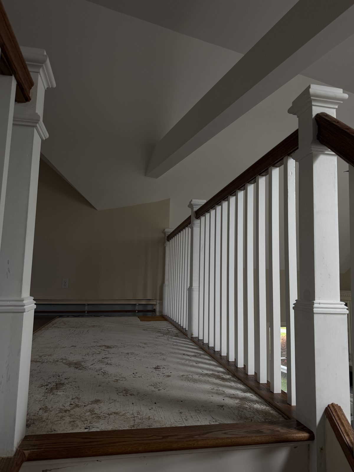 Upper landing with square newel posts, white balusters and a fitted red oak nosing during the Rehoboth custom staircase rebuild.